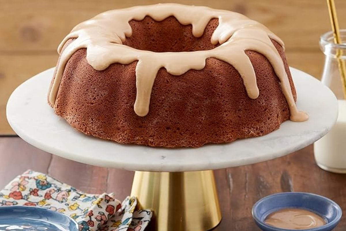 bundt cake with icing on cake stand. 
