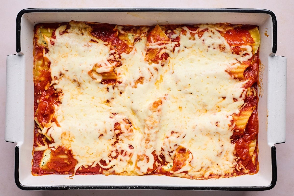 baked manicotti with mozzarella cheese in baking dish. 