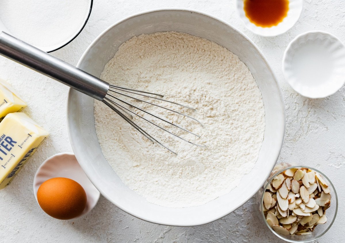 dry ingredients being whisked together in mixing bowl with whisk. 