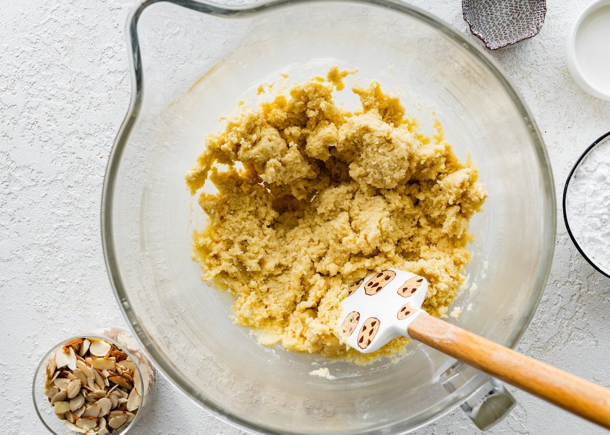 almond cookie dough in mixing bowl with spatula. 