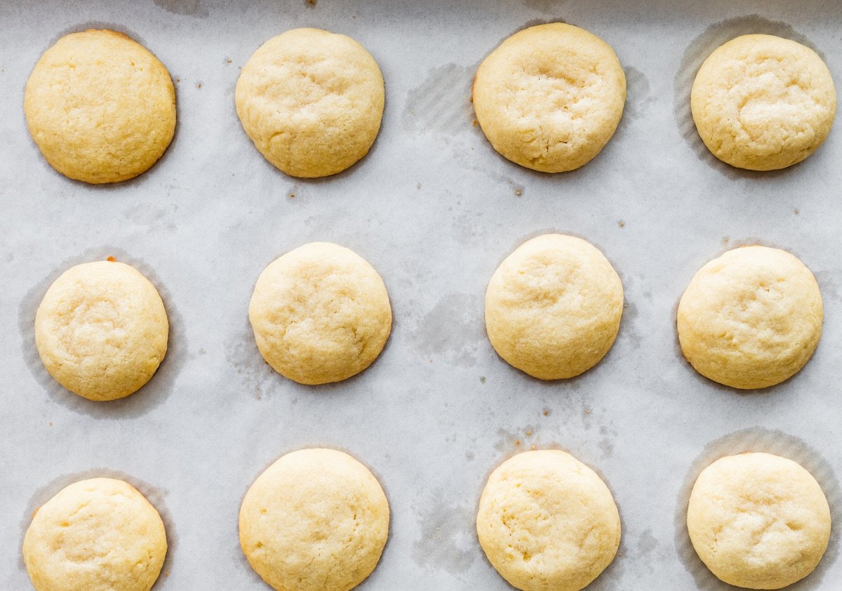 almond cookies on baking sheet with parchment paper. 