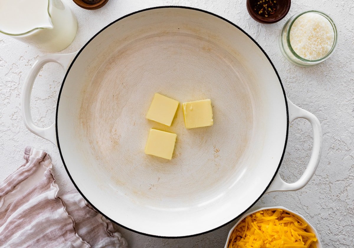 butter melting in a white pot to make broccoli mac and cheese. 