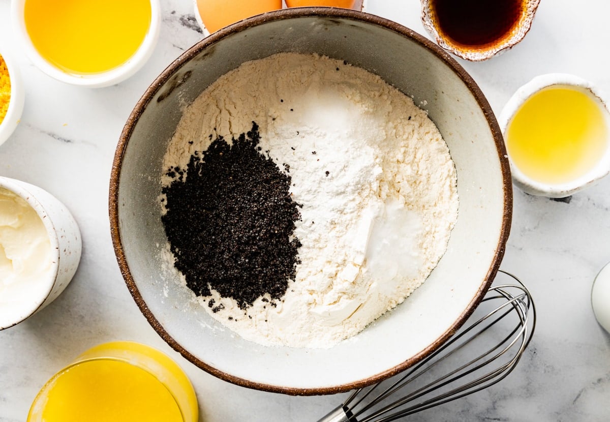 flour, baking soda, baking powder, salt, and poppy seeds in mixing bowl to make lemon poppy seed muffins. 