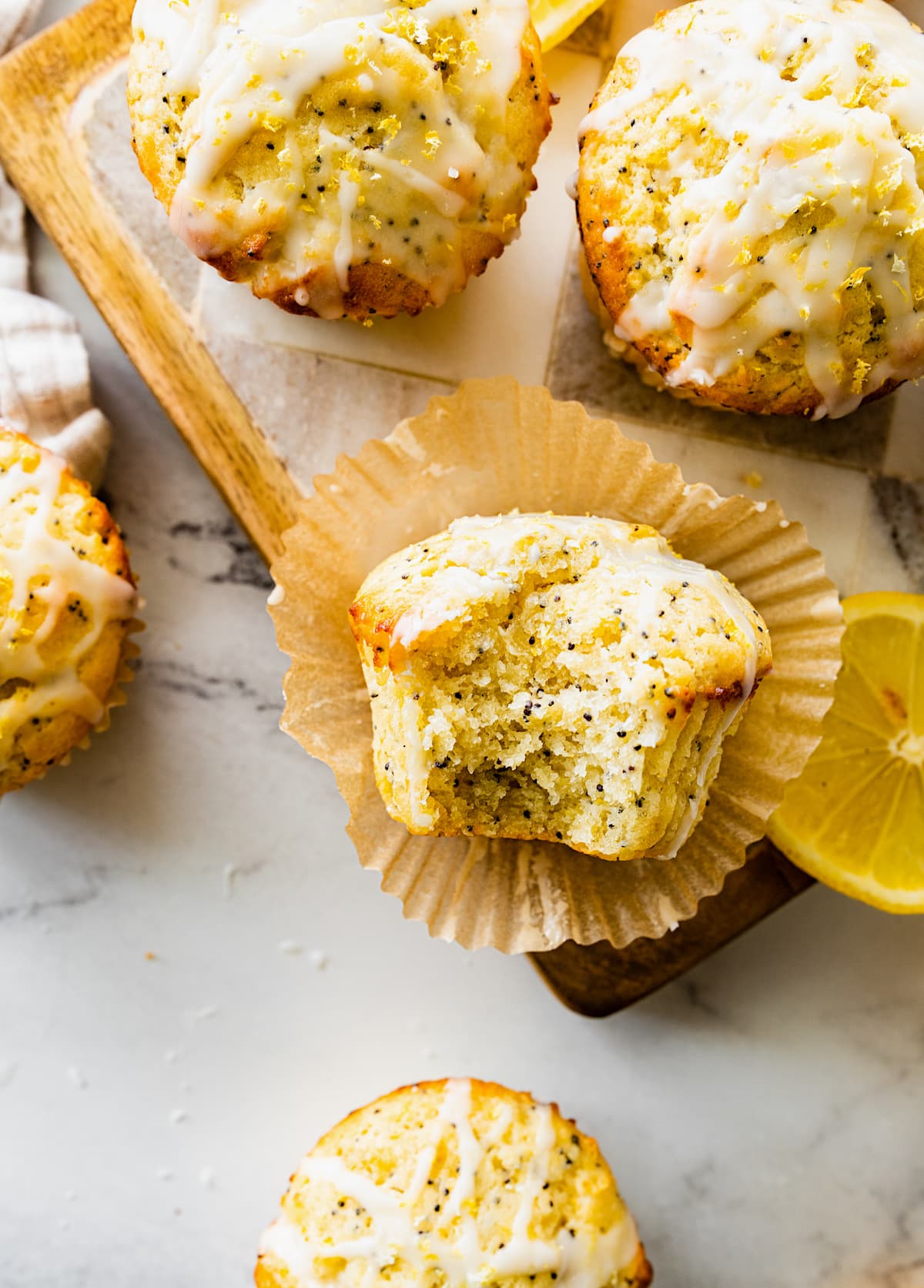 bite taken out of a lemon poppy seed muffin with lemon glaze. 