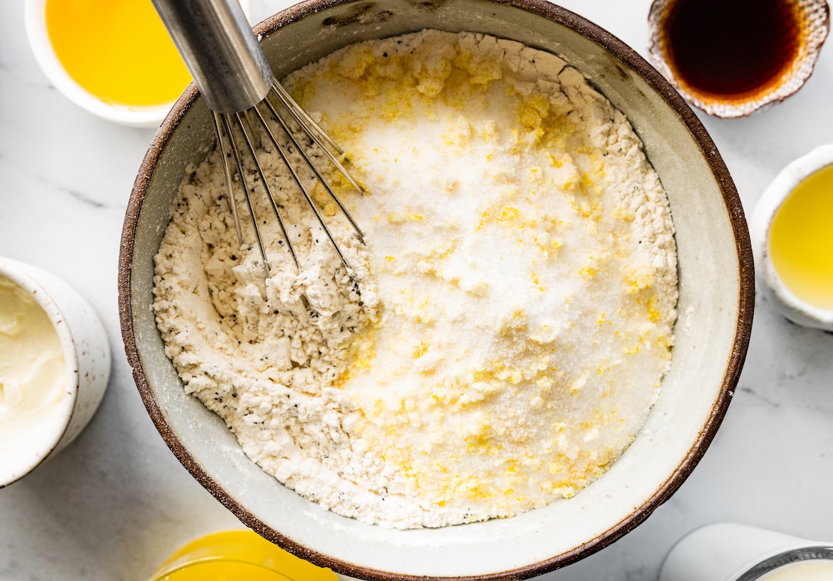 whisking together dry ingredients in mixing bowl to make lemon poppy seed muffins. 