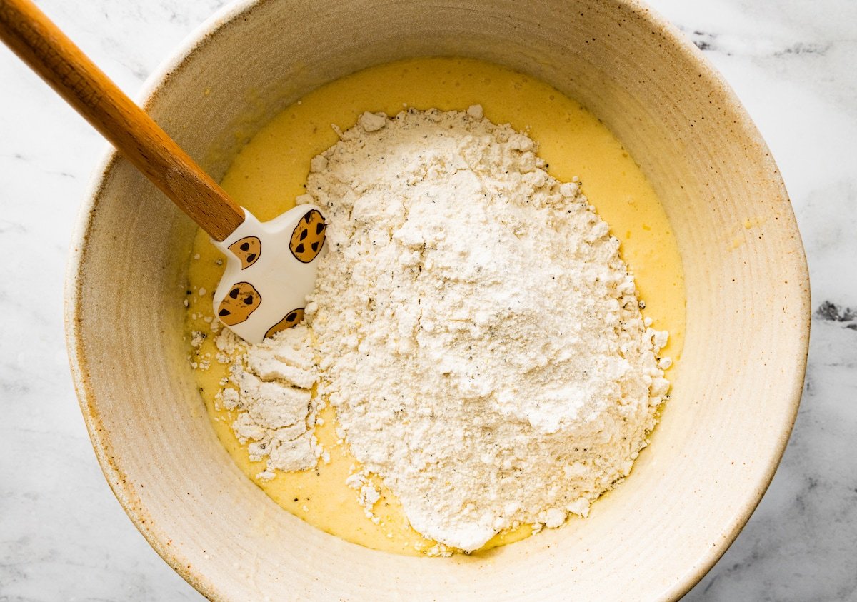 making lemon poppy seed muffin batter in mixing bowl with spatula. 