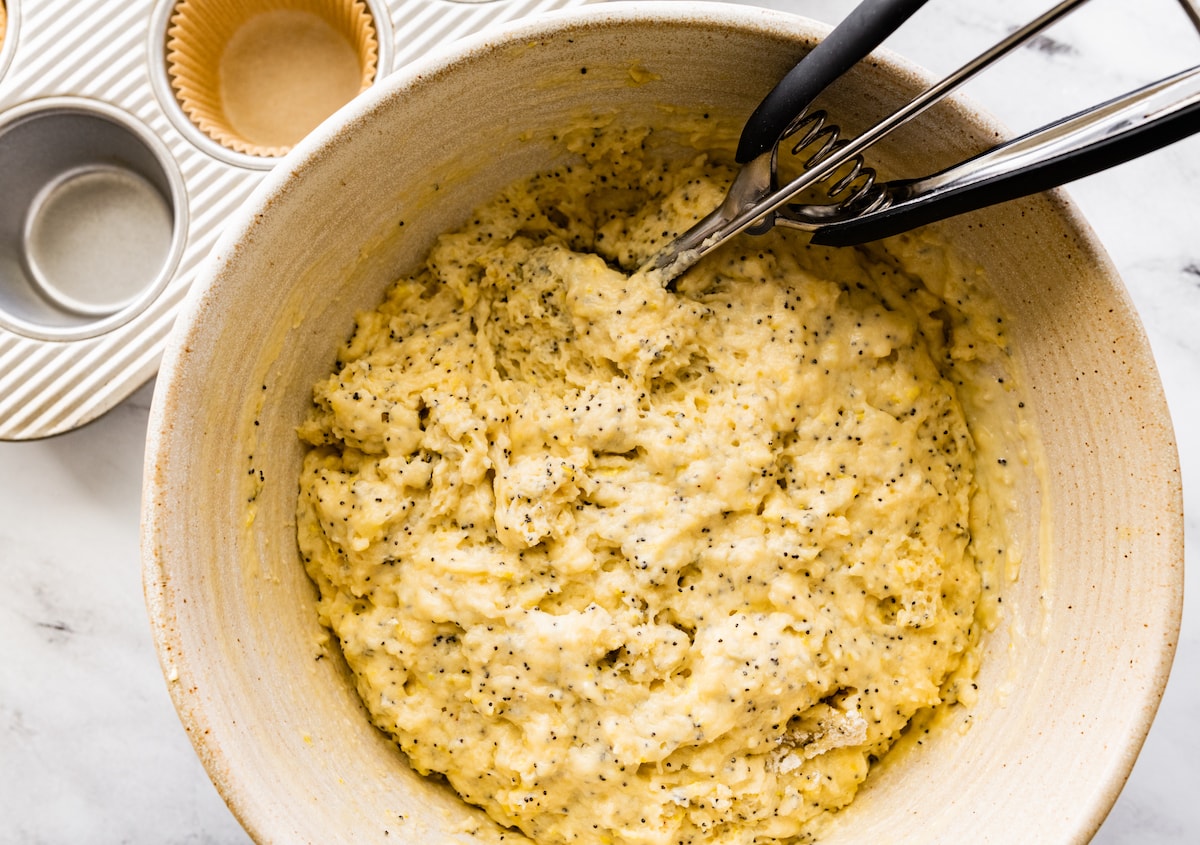 lemon poppy seed muffin batter in bowl with scoop. 