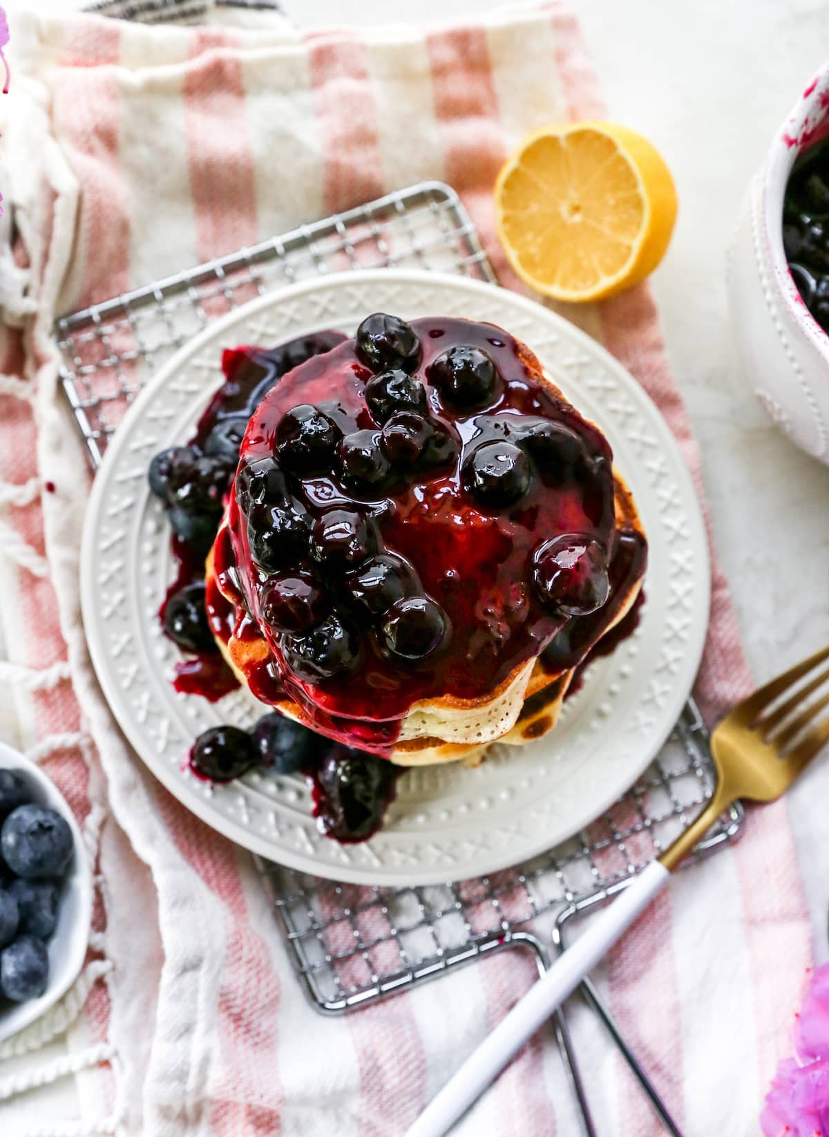 lemon ricotta pancakes with blueberry sauce on plate with fork.