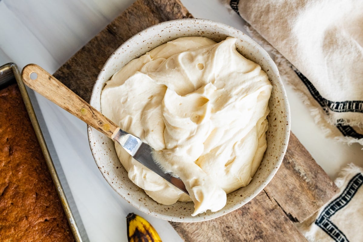 cream cheese frosting in bowl with icing spatula. 