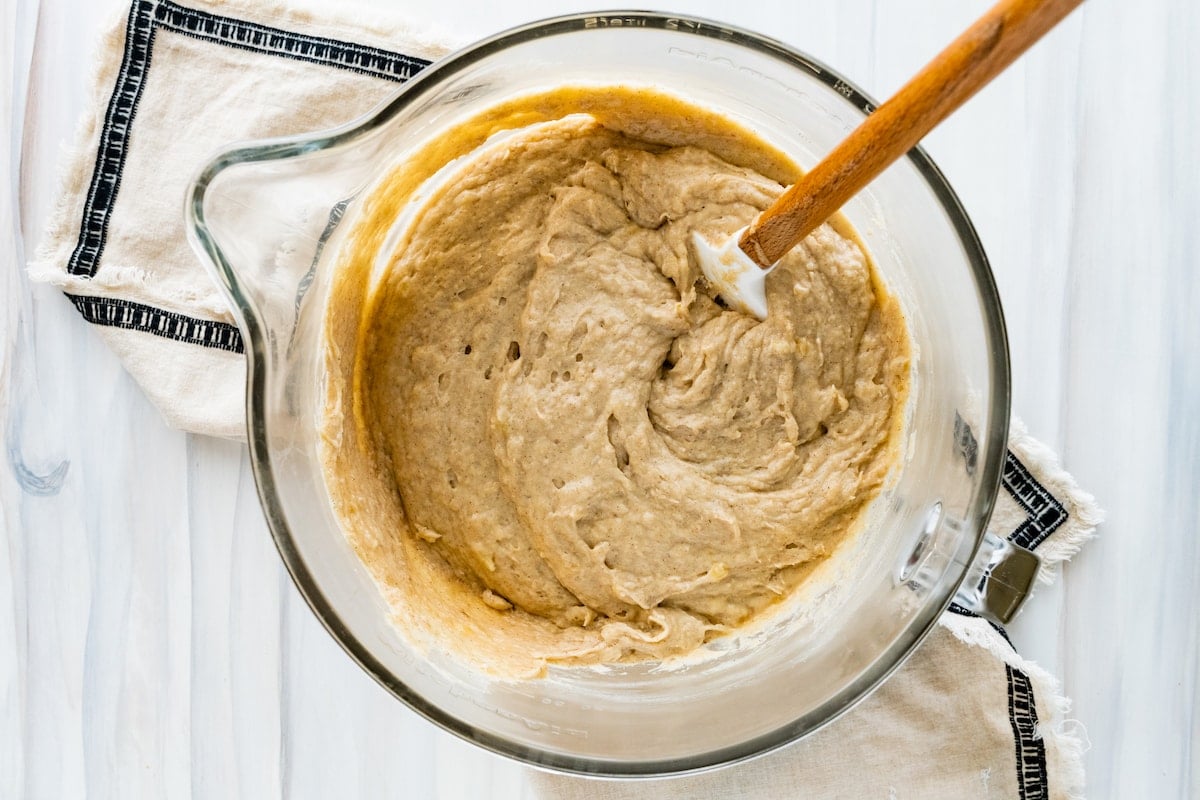 banana cake batter in mixing bowl with spatula. 