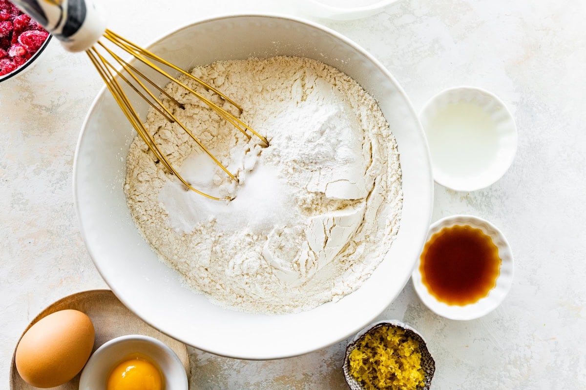 dry ingredients being whisked together in mixing bowl with whisk. 