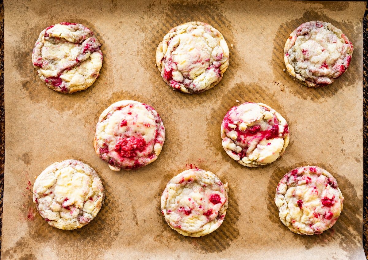 baked lemon raspberry cookies on baking sheet with parchment paper. 