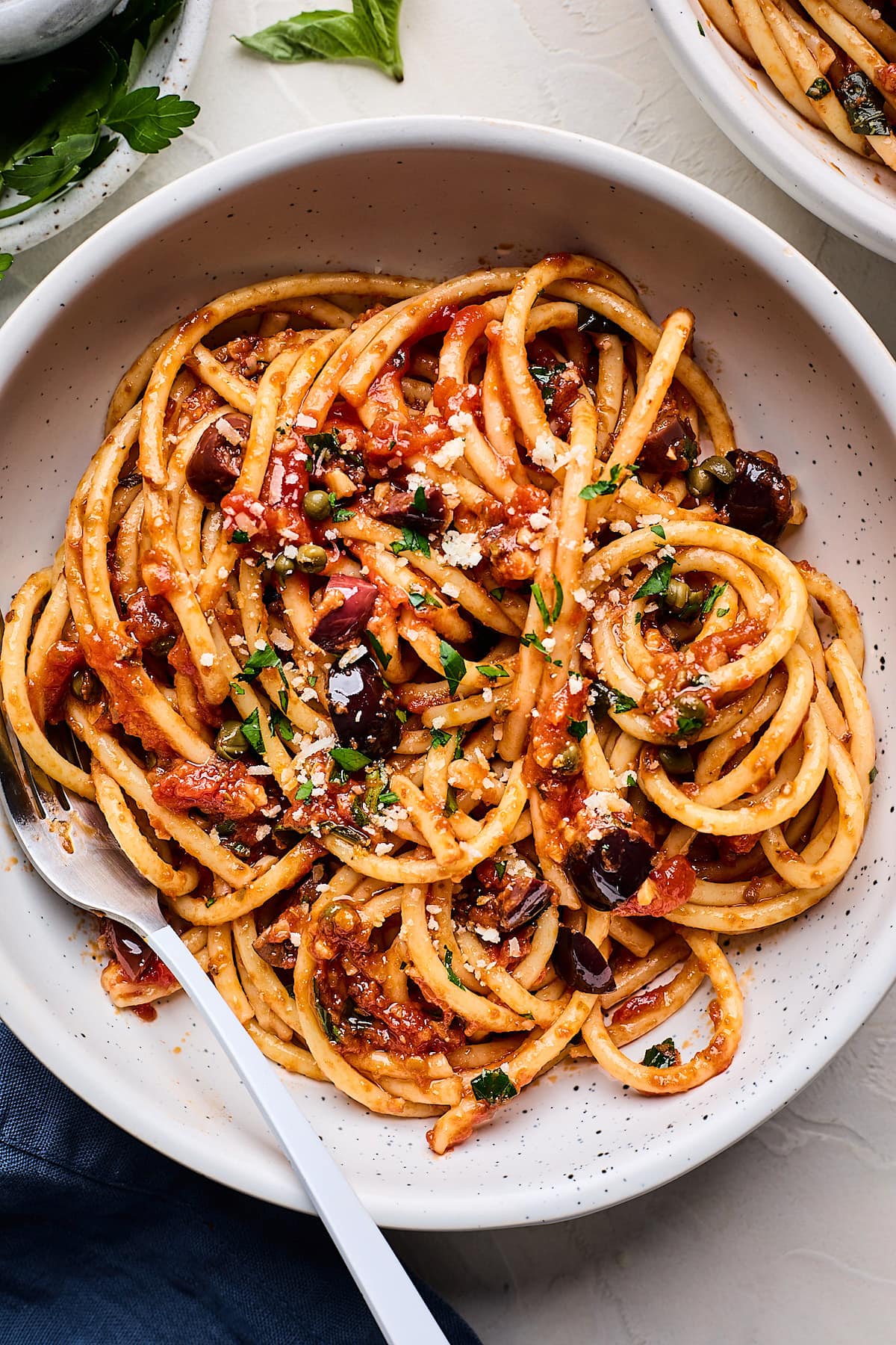 pasta puttanesca in bowl with fork. 