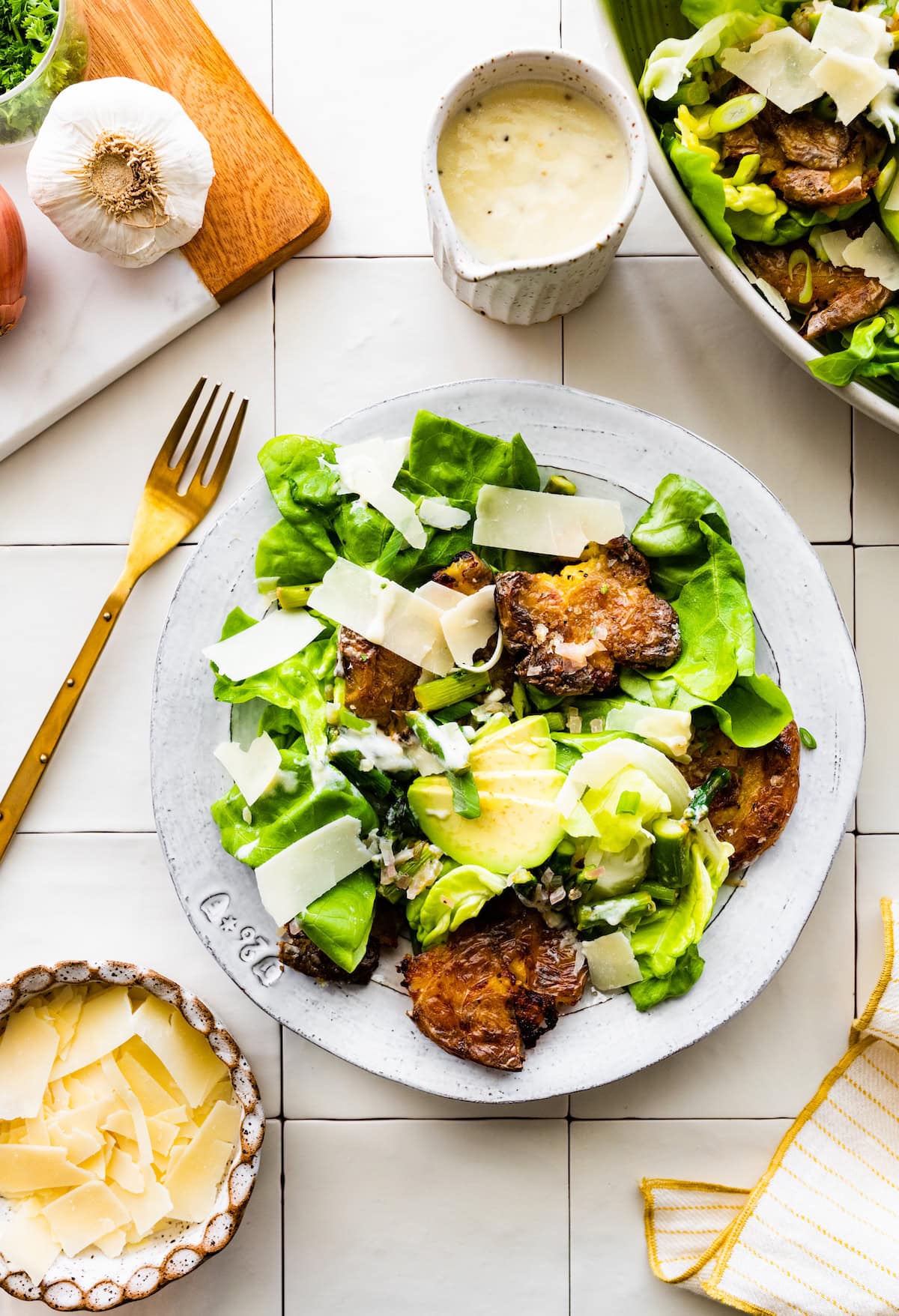 smashed potato spring salad on plate with gold fork. 