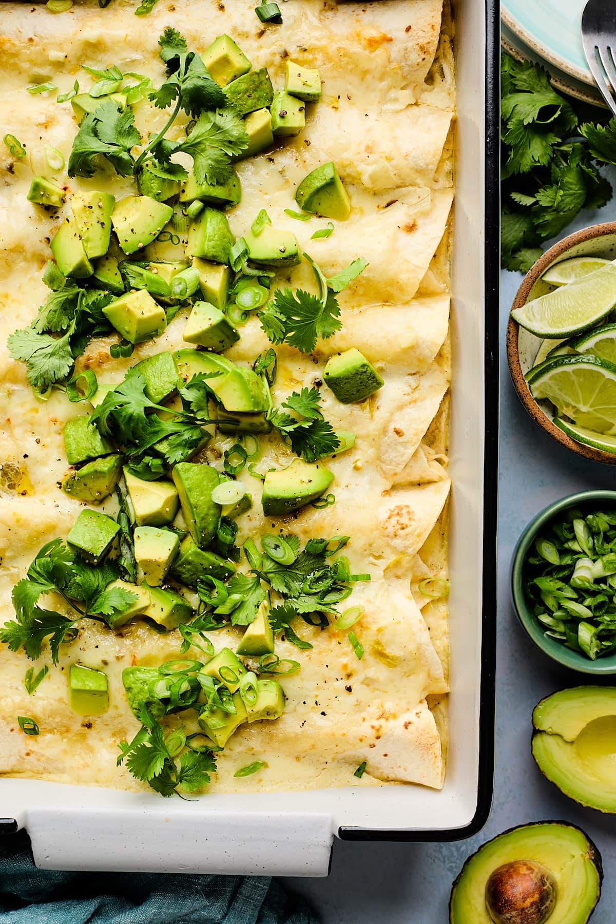 white chicken enchiladas in pan with toppings. 