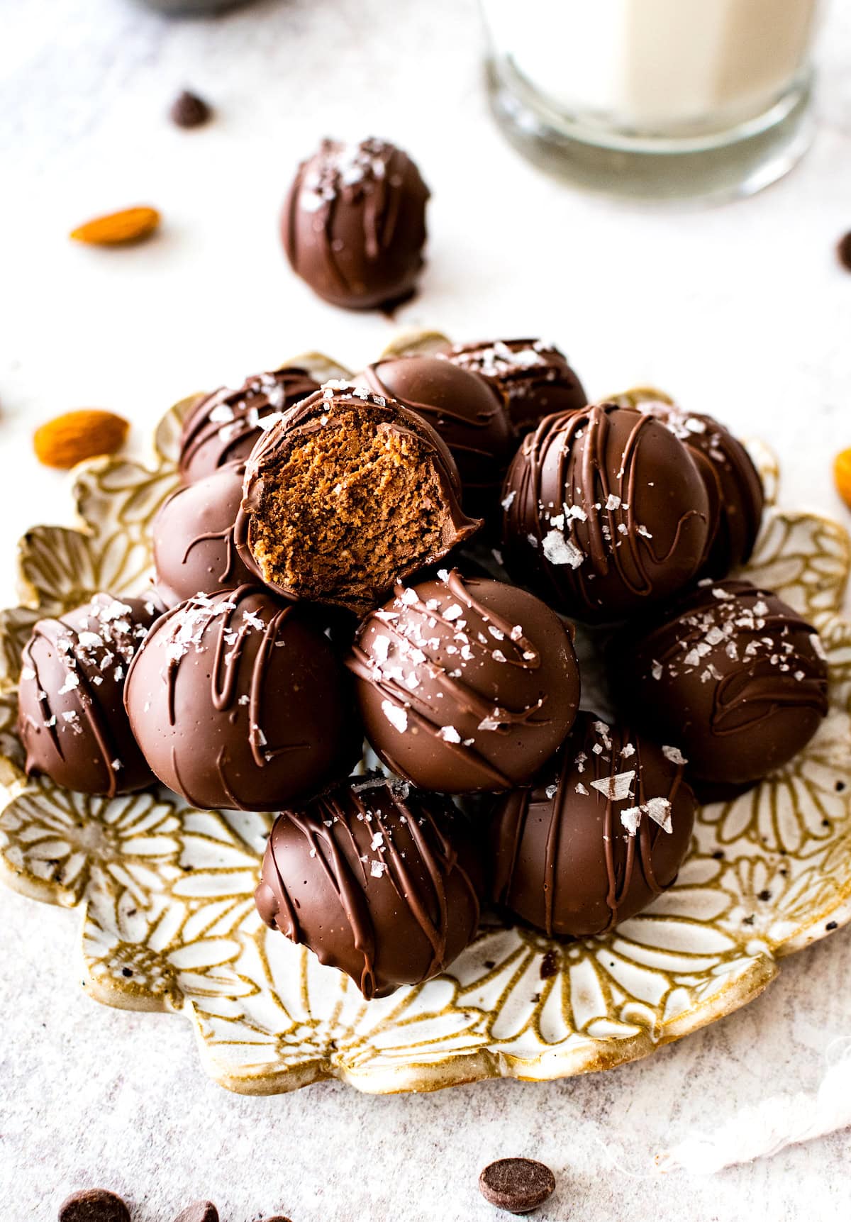 chocolate brownie protein balls on plate, one with bite taken out. 