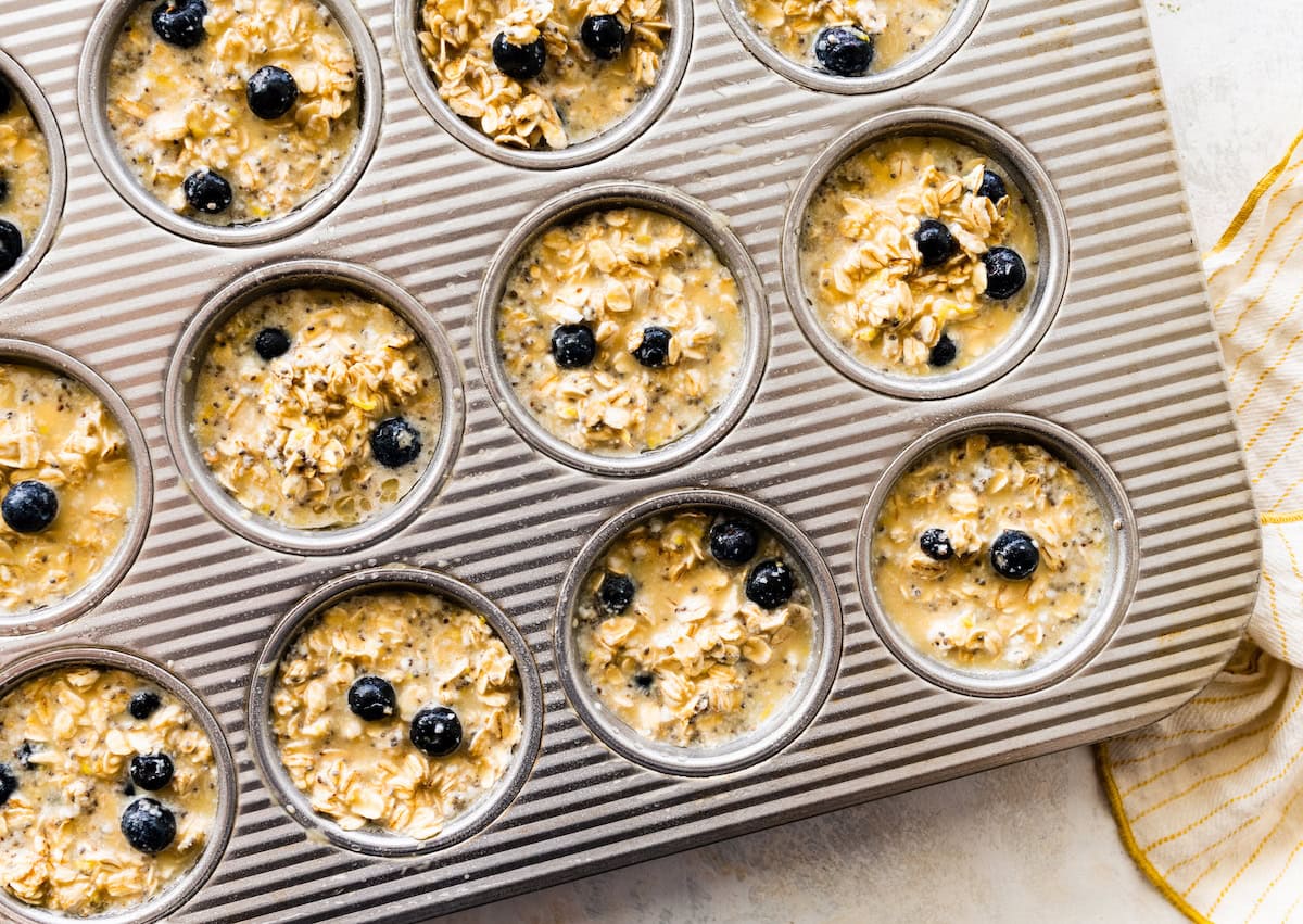 lemon blueberry baked oatmeal cups in muffin pan getting ready to be baked. 