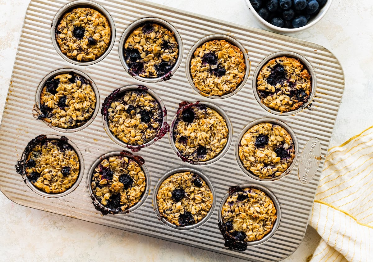 lemon blueberry baked oatmeal cups in muffin pan. 