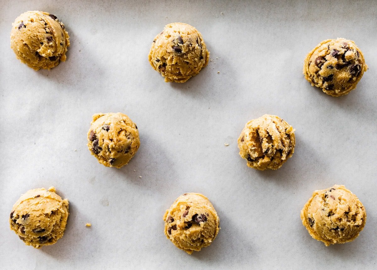 graham cracker toffee chocolate chip cookie dough balls on baking sheet with parchment paper. 