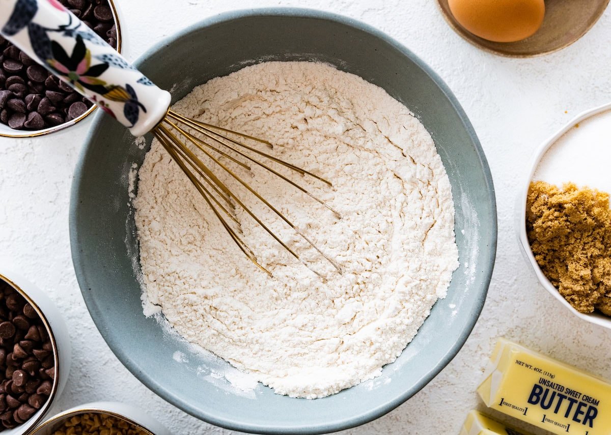 dry ingredients being whisked together in bowl to make cookies. 