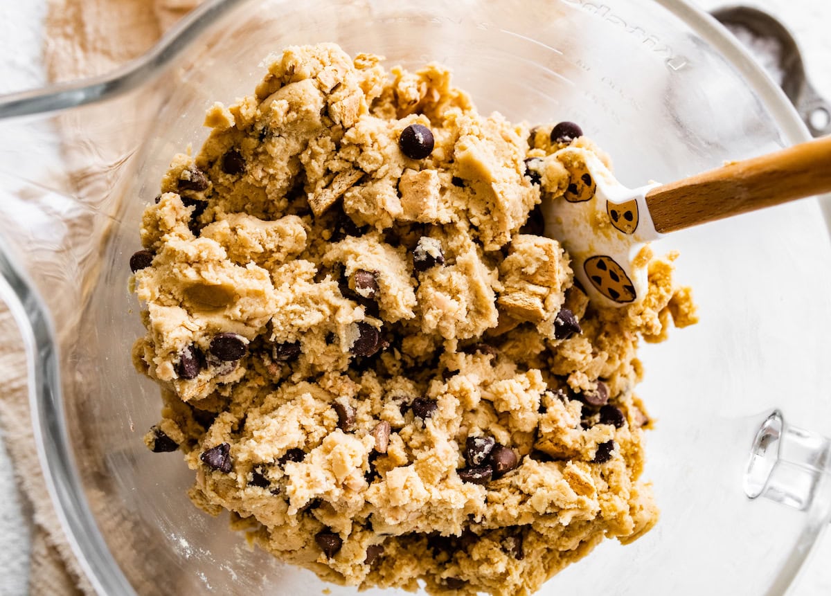 graham cracker toffee chocolate chip cookie dough in mixing bowl with spatula. 