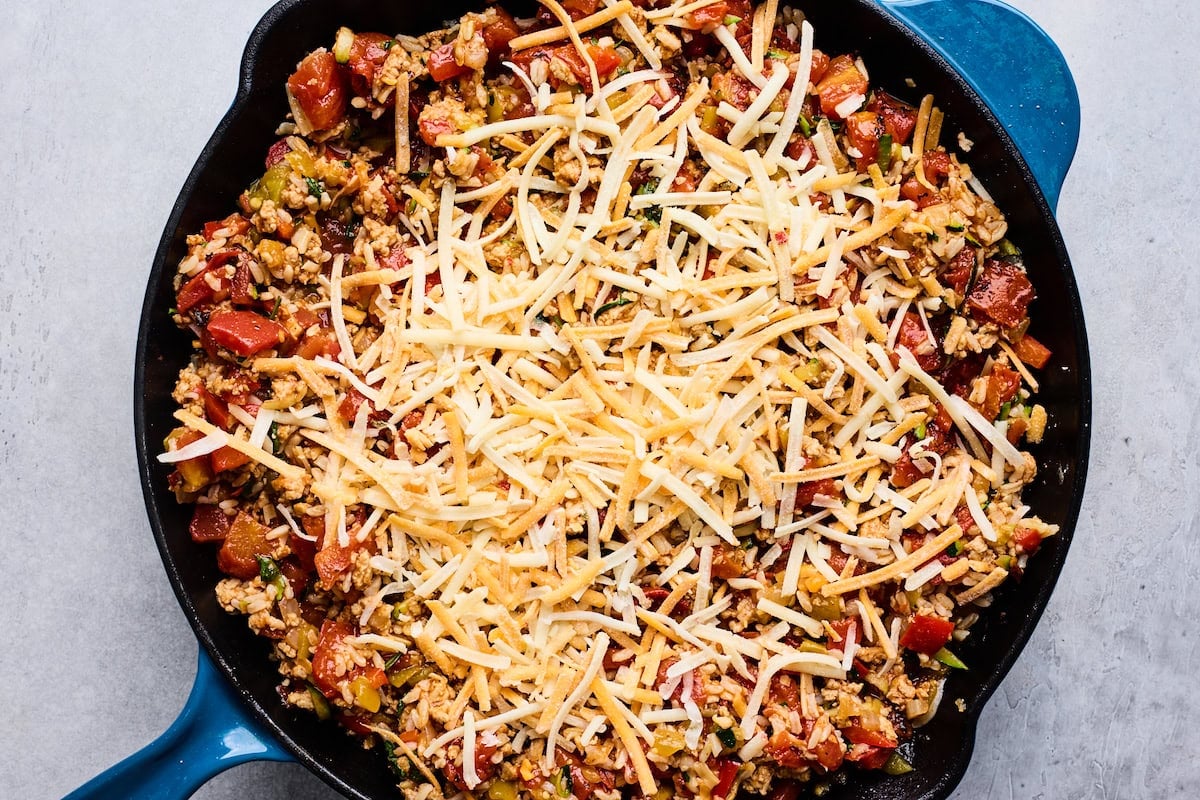 ground turkey taco skillet covered in shredded cheese.