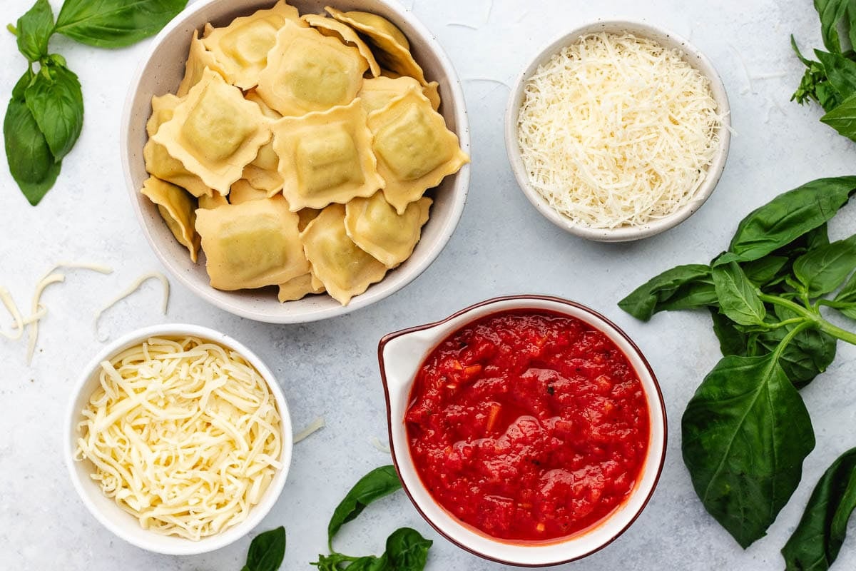 ingredients in bowls to make ravioli lasagna.