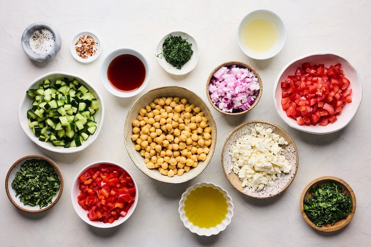 ingredients in bowls to make Mediterranean Chickpea Salad.