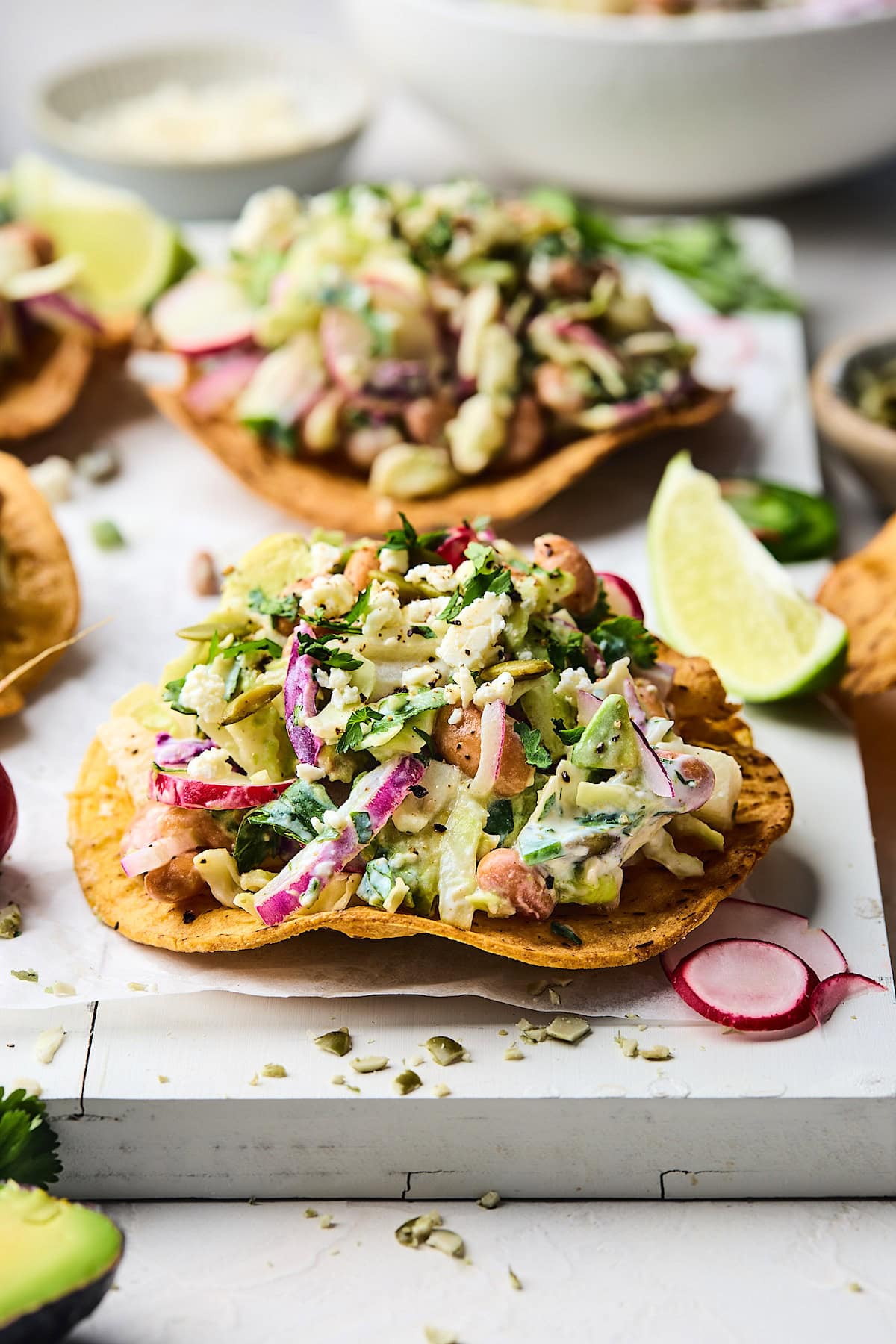 crispy tostada with cabbage salad on top with beans, avocado, cilantro, radish, jicama, and a creamy cilantro lime dressing.