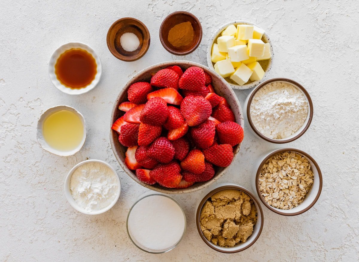 ingredients in bowls to make strawberry crisp.