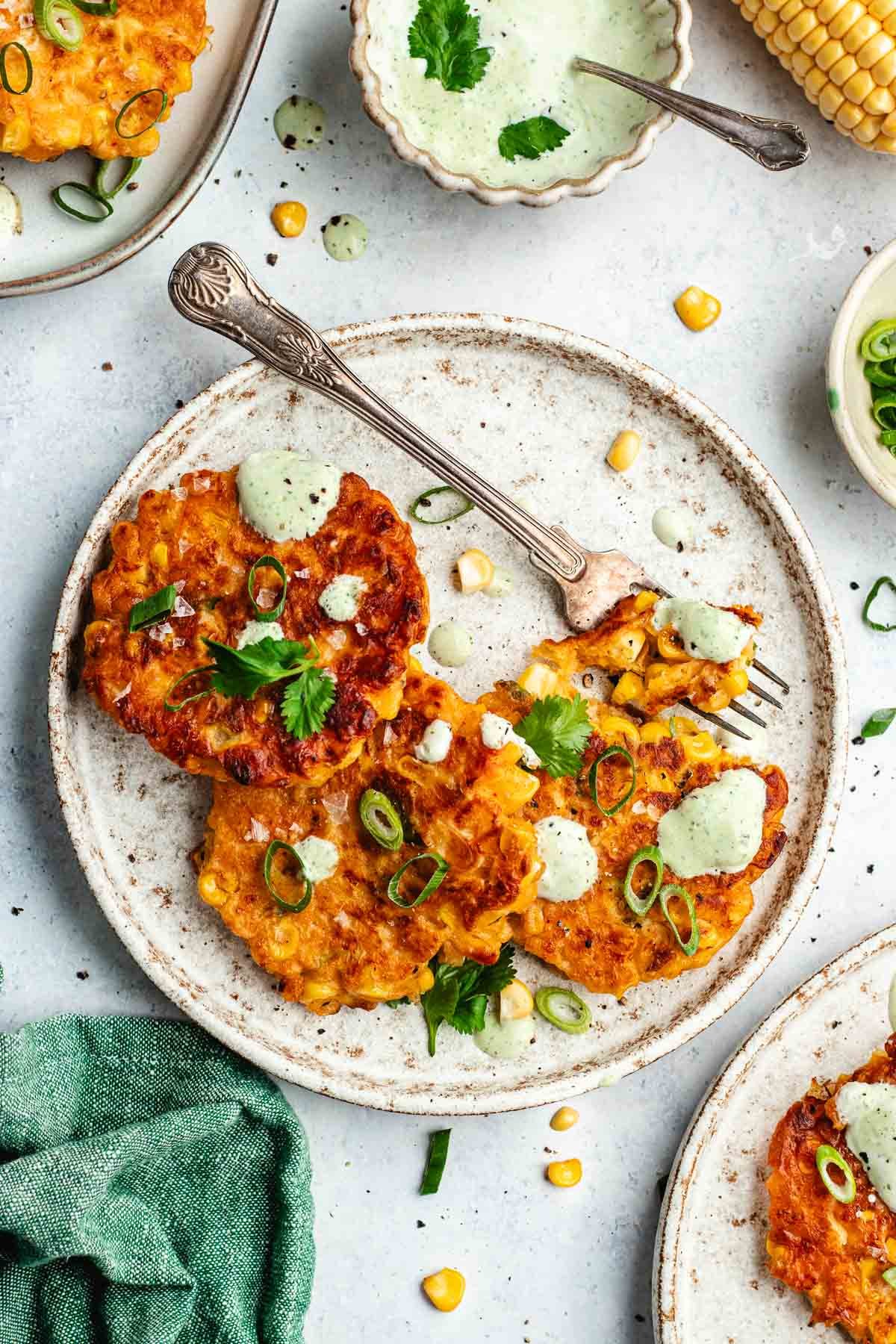 corn fritters on plate with fork.
