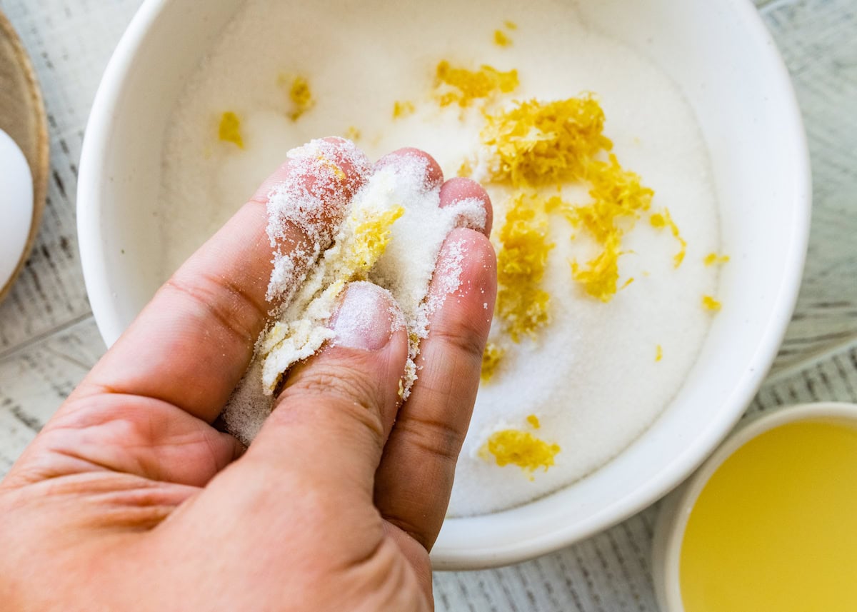 rubbing granulated sugar and lemon zest together to make lemon blueberry muffins. 