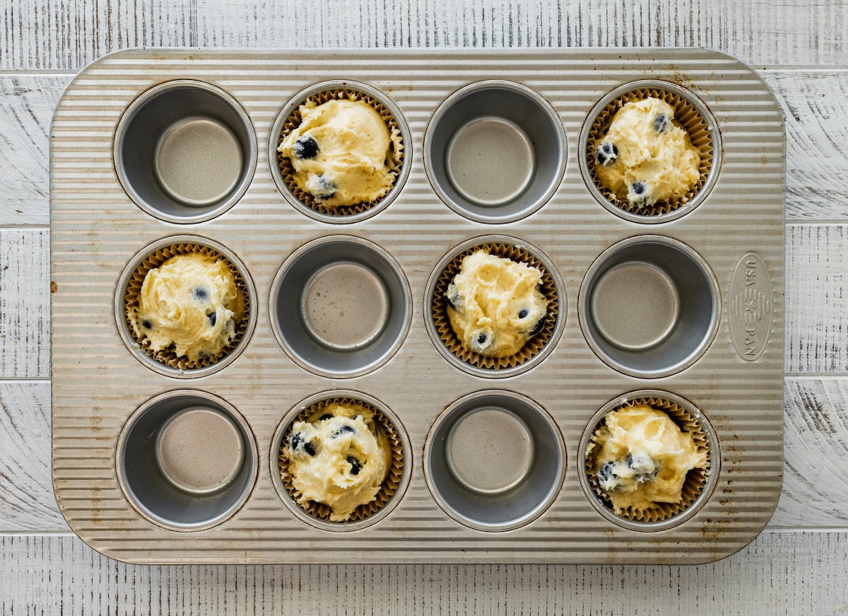 lemon blueberry muffin batter in muffin pan cups, ready for the oven. 