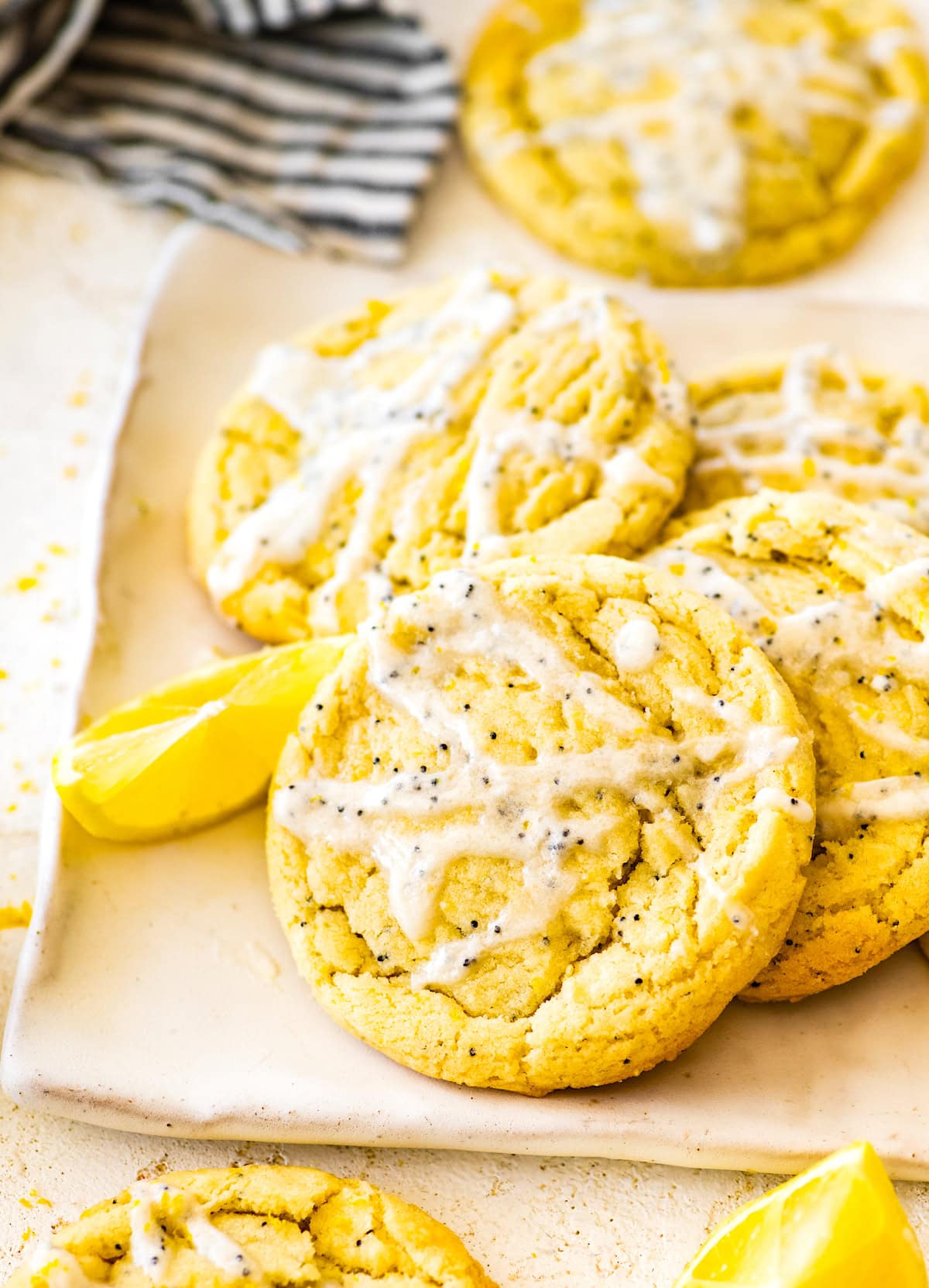 lemon poppy seed cookies on tray with lemon wedge. 