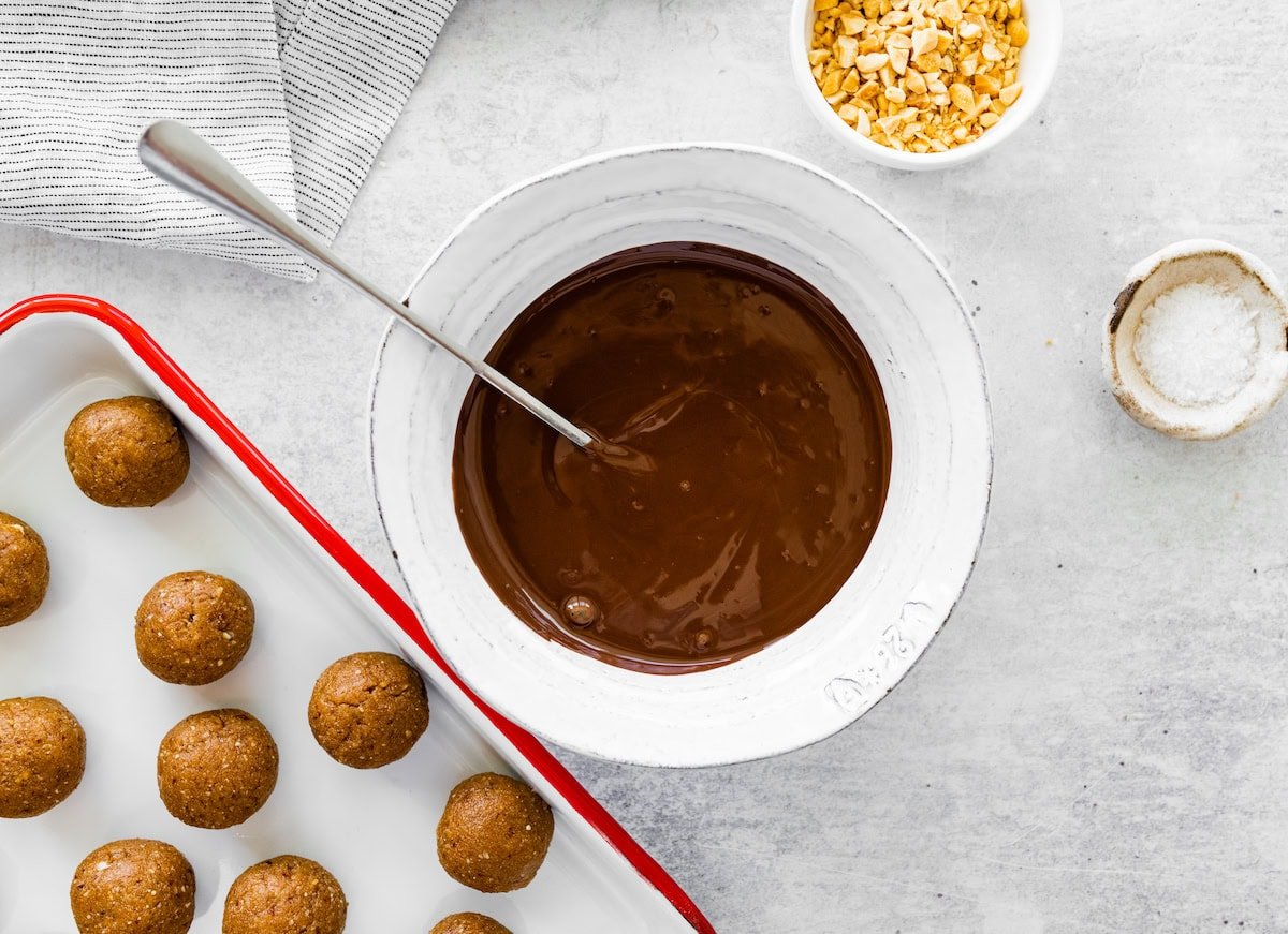 snickers protein balls ready to be dipped in melted chocolate.