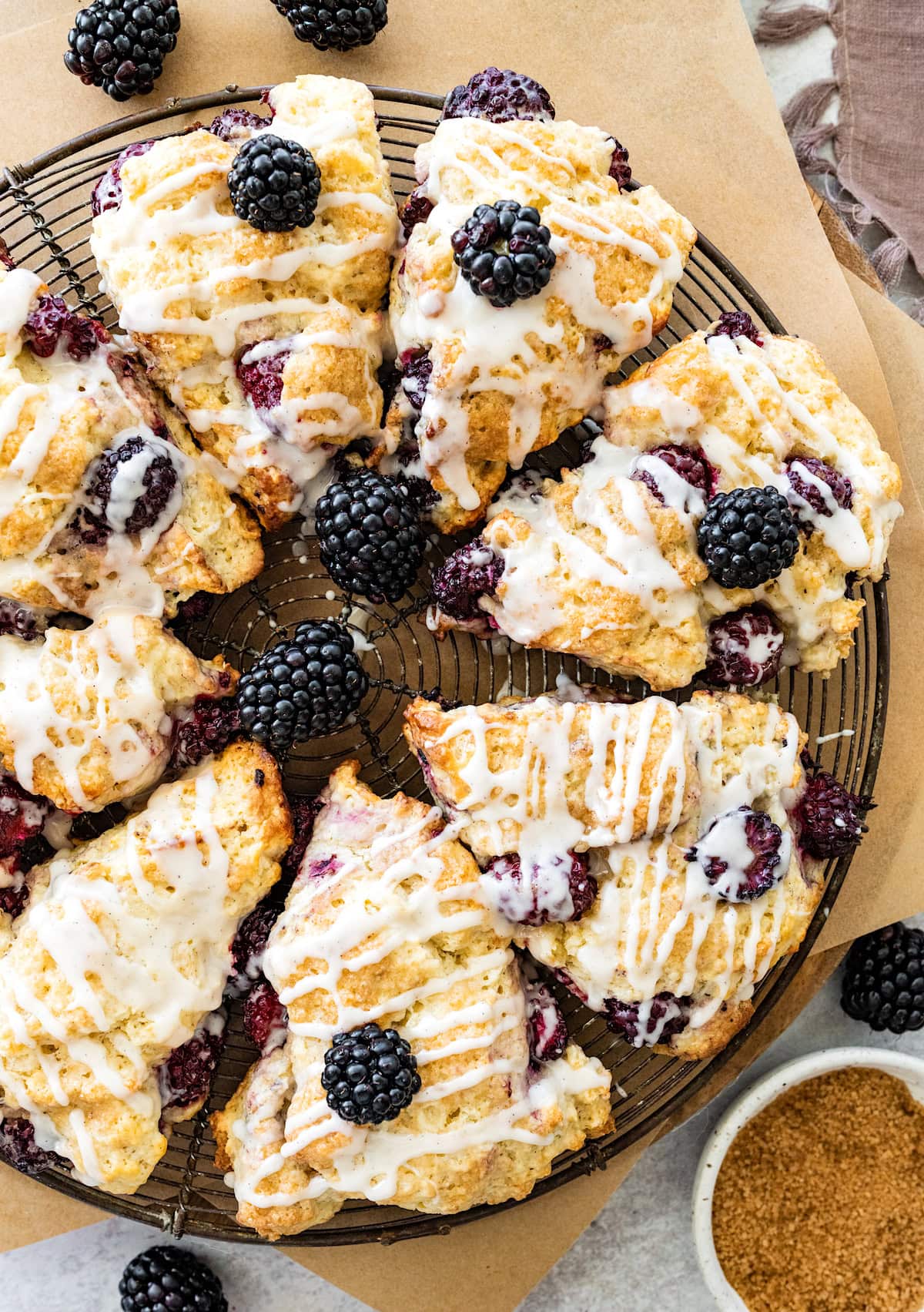 blackberry scones with vanilla glaze on cooling rack. 