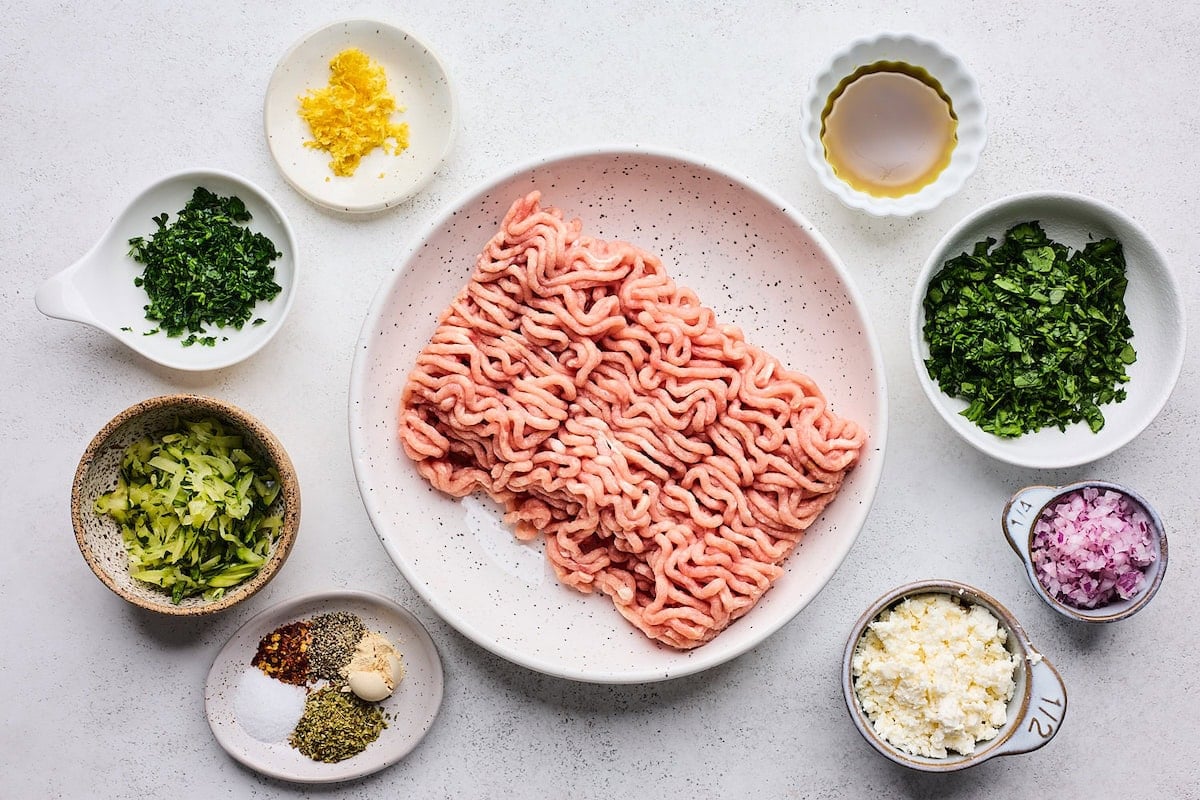 ingredients in bowls to make Greek turkey burgers.
