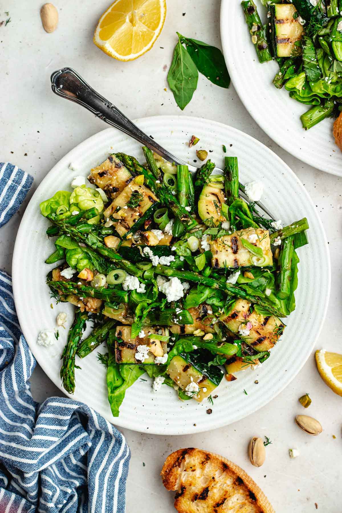 grilled asparagus and zucchini salad on plate with fork.