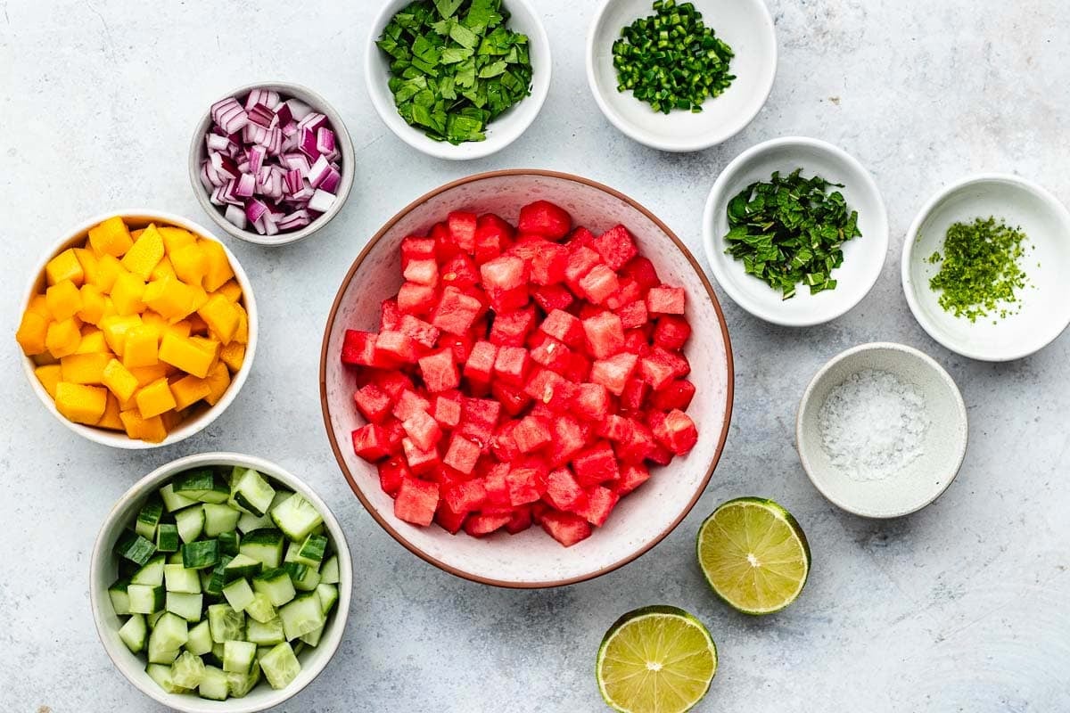 ingredients in bowls to make watermelon mango salsa. 