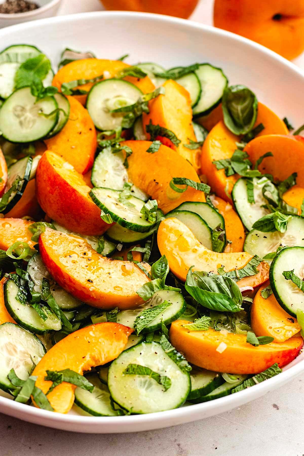 close up of peach cucumber salad with fresh herbs.