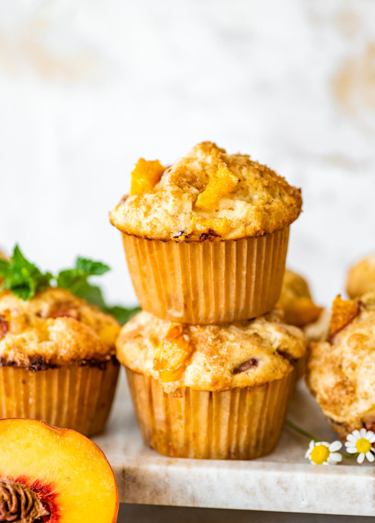 2 peach muffins stacked on marble tray.
