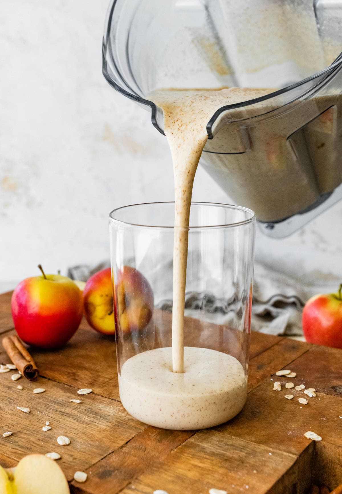 creamy apple smoothie being poured into a glass from the blender.