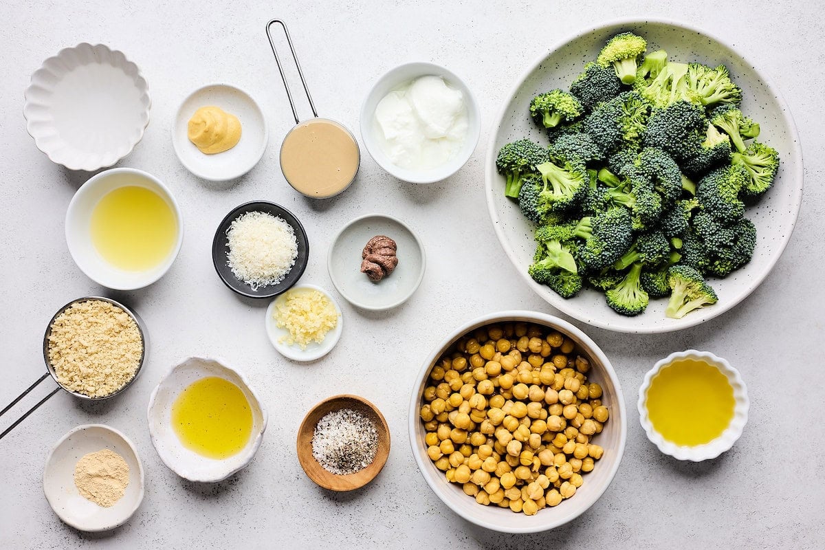 Ingredients in bowls to make broccoli caesar salad with chickpeas.