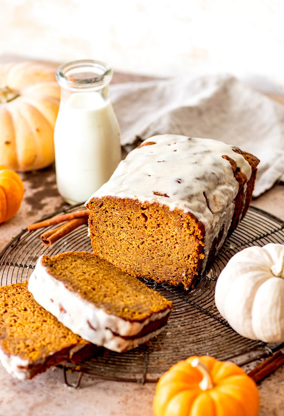 brown butter pumpkin bread with brown butter maple glaze on cooling rack cut into slices. 