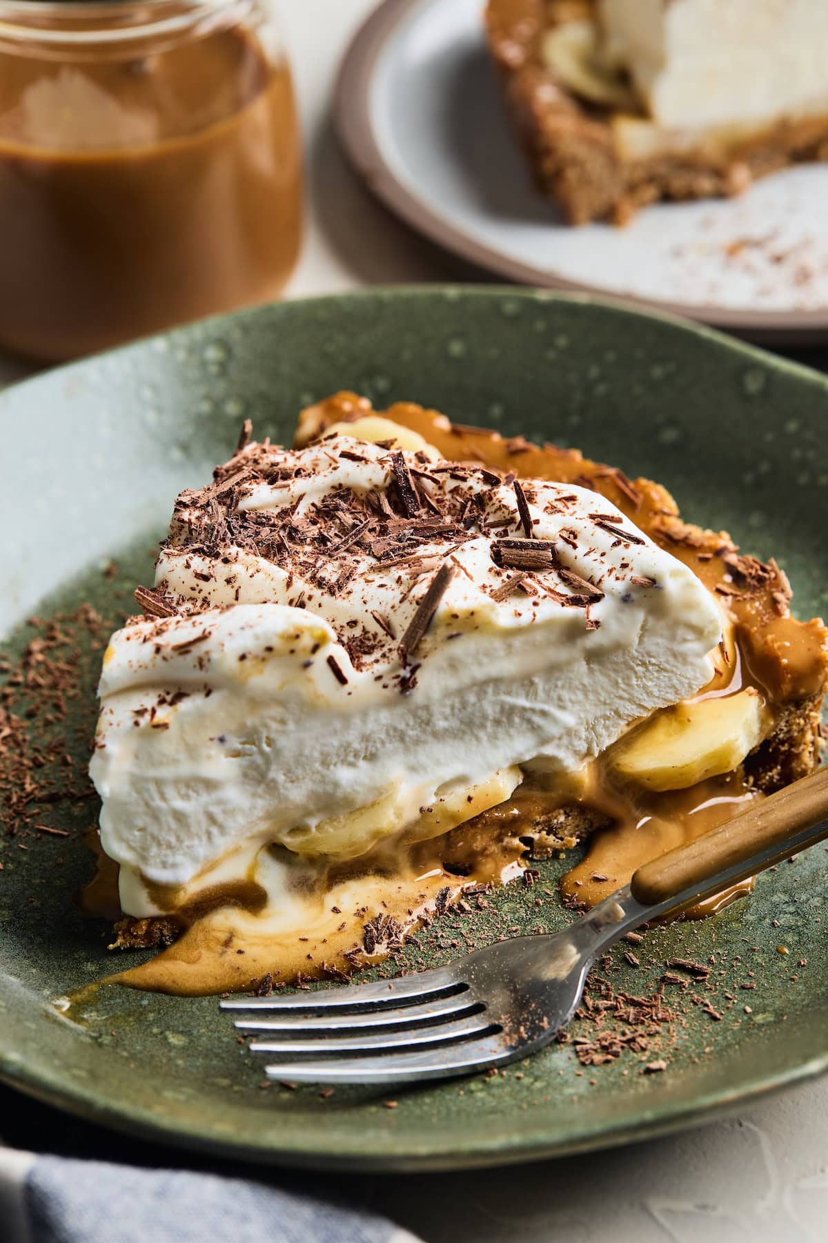 A close up of a piece of banoffee pie on a plate with fork.