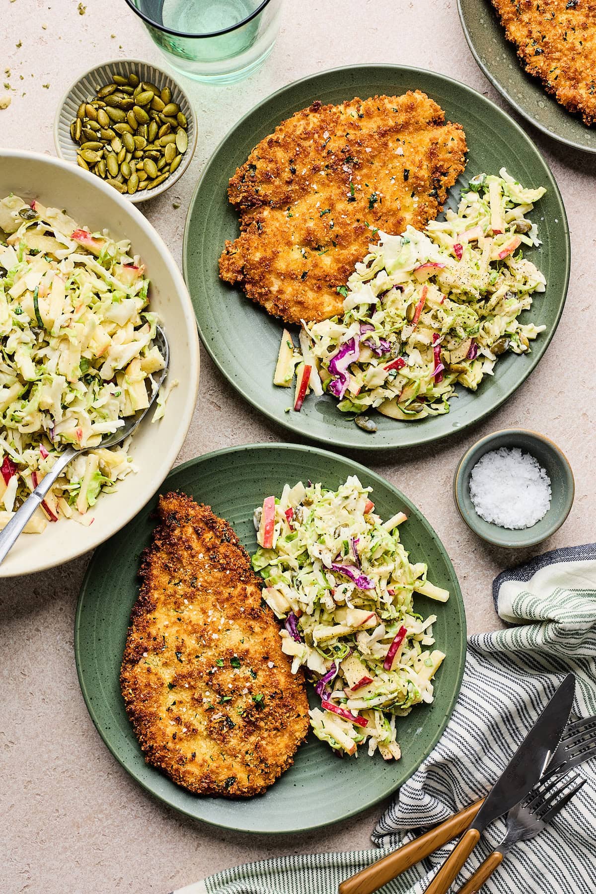 crispy chicken cutlets with apple slaw on plates.