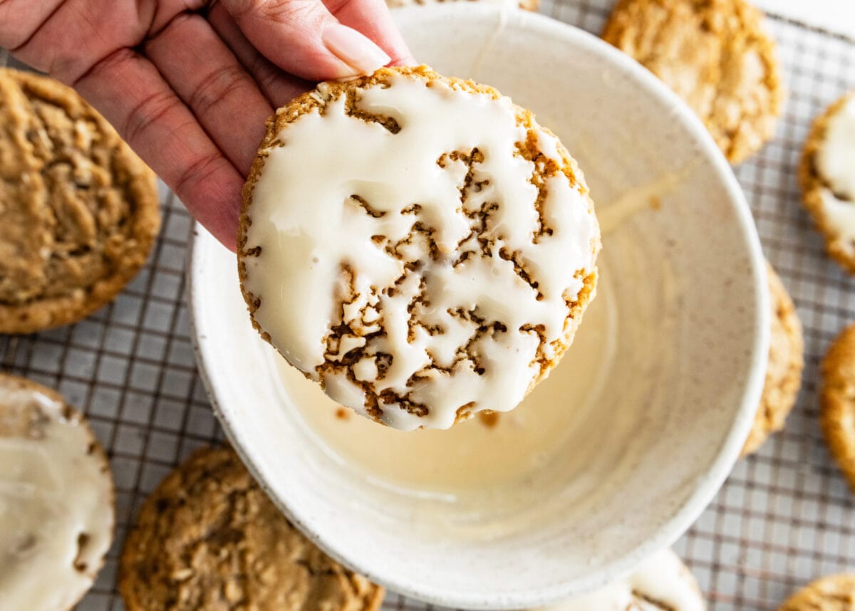 eggnog iced oatmeal cookie after being dipped into the bowl of icing. 