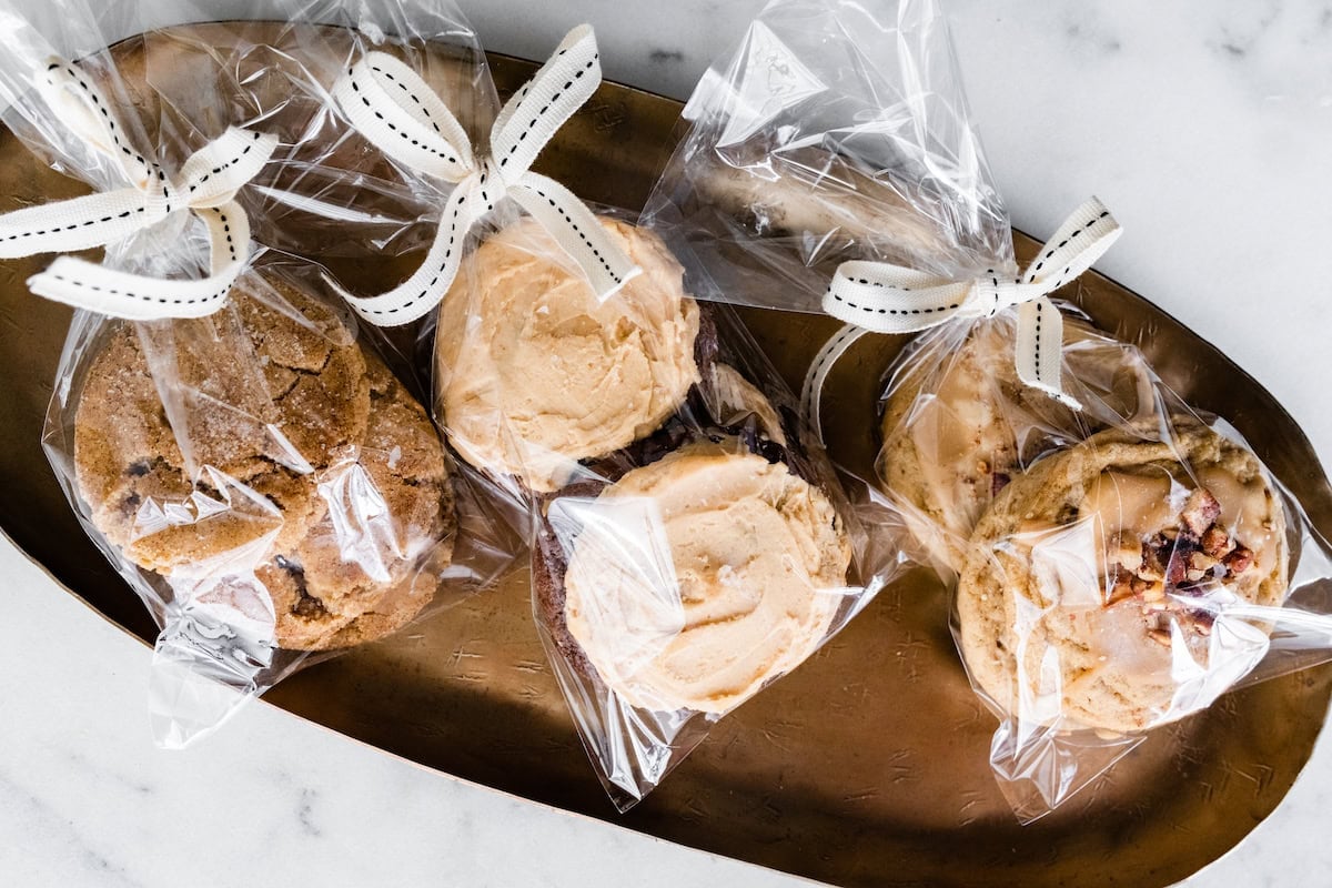 cookies in clear bags tied with ribbons on platter for gifting. 
