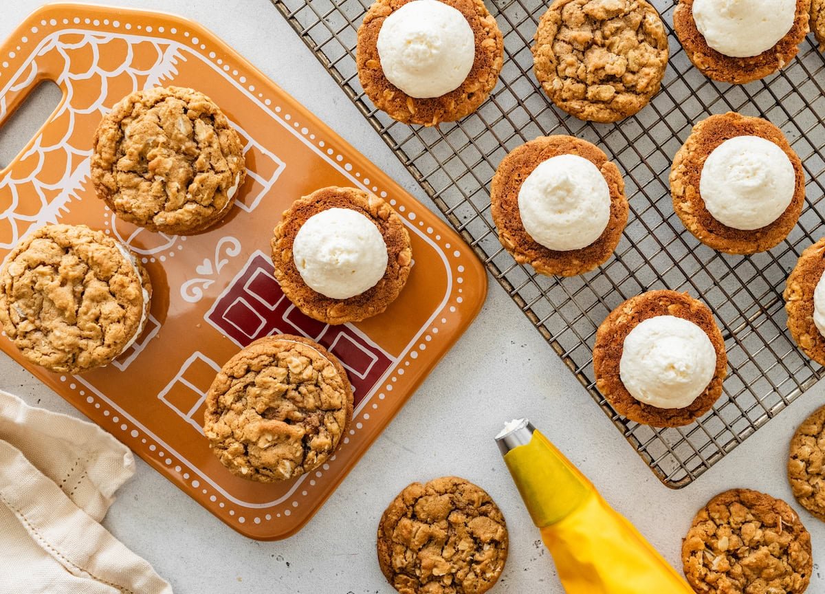 assembling gingerbread oatmeal cream pies with vanilla cream filling on cooling rack and plate.