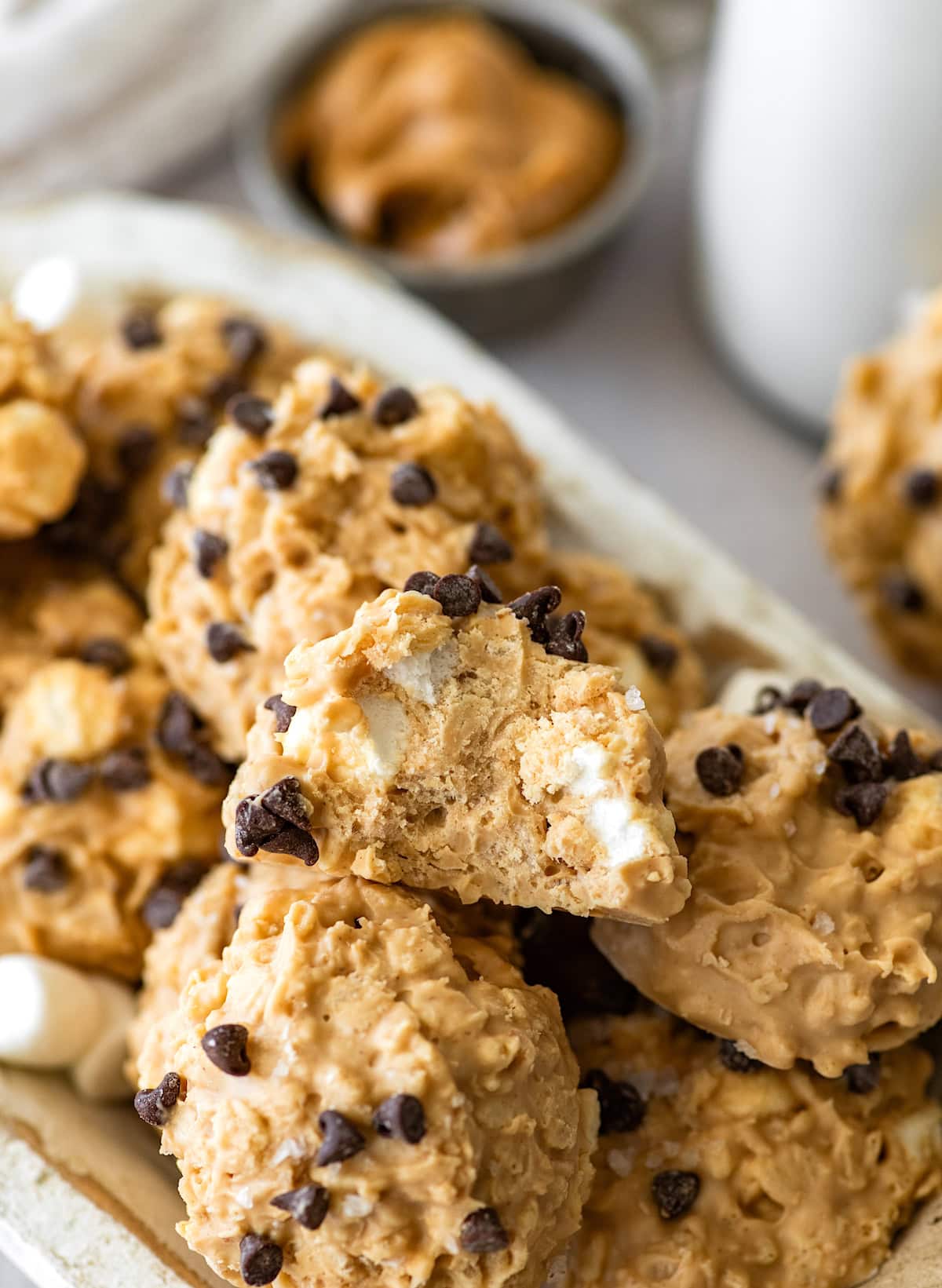 close up of an avalanche cookie with a bite taken out of it on a platter with other cookies. 